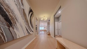 Un couloir avec un mur en marbre, un plancher en bois et un banc.
