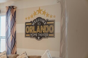 A wall sign with 'WELCOME TO ORLANDO HOME THEATER' text and decorative stars. - Go!#41 - WINDSOR AT WESTSIDE (Kissimmee)