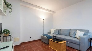A living room with a grey sofa, a wooden coffee table, a floor lamp, and a TV on a stand. - Casa De Invitados El Rincon De Itara (Firgas)