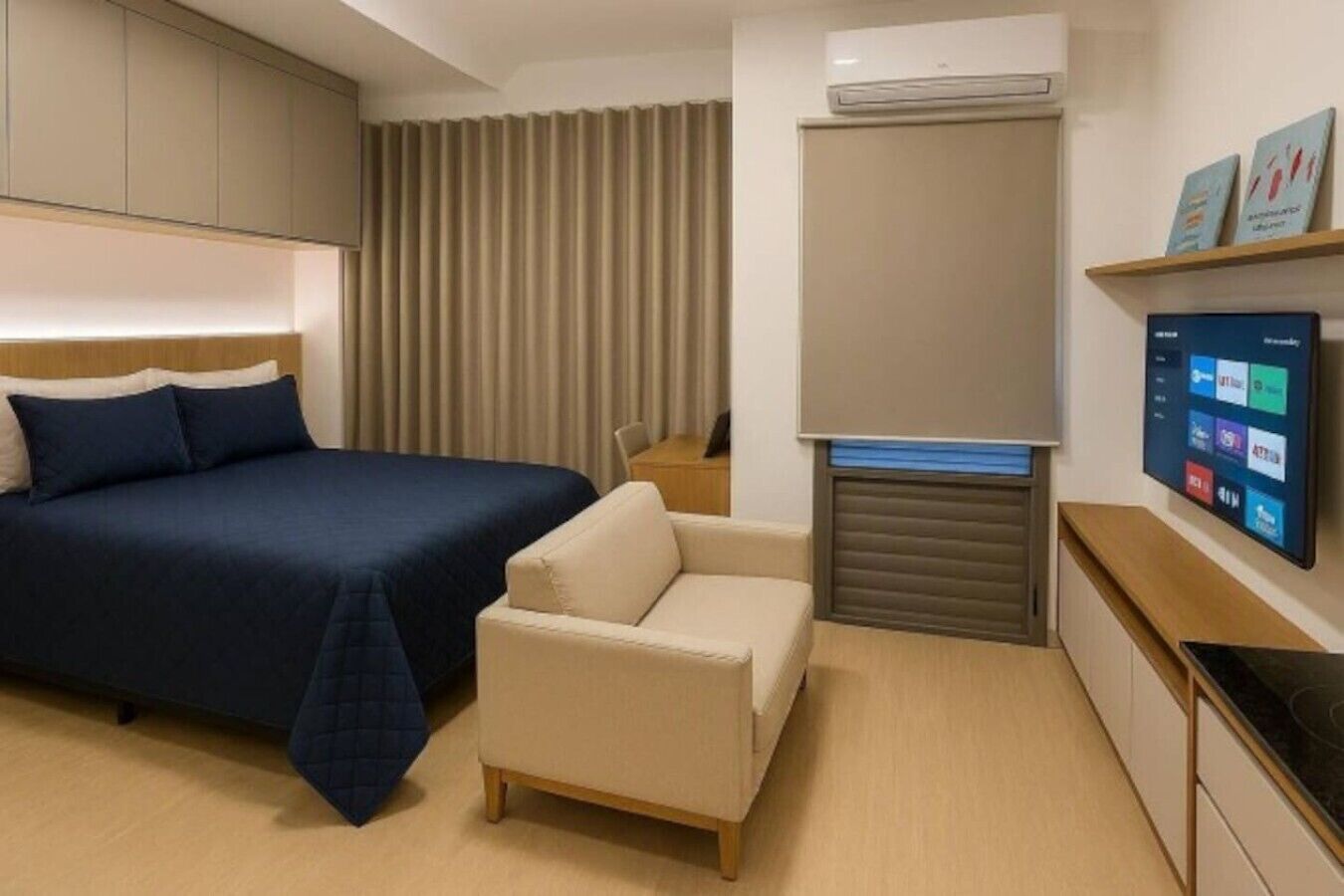 Una habitación de hotel con cama, sofá, escritorio, unidad de aire acondicionado y televisor montado.