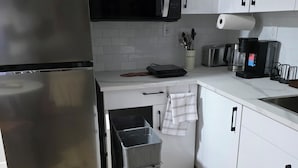 Una cucina moderna con un frigorifero in acciaio inossidabile, un forno a microonde e una macchina per il caffè.