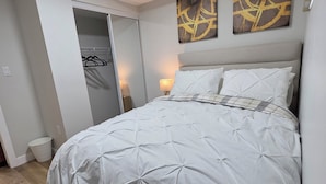 Una camera da letto con un letto, un armadio e due quadri appesi al muro.