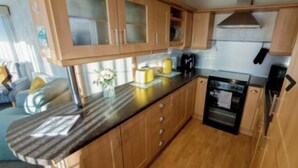 Una cocina compacta con armarios de madera, una encimera y un horno empotrado.