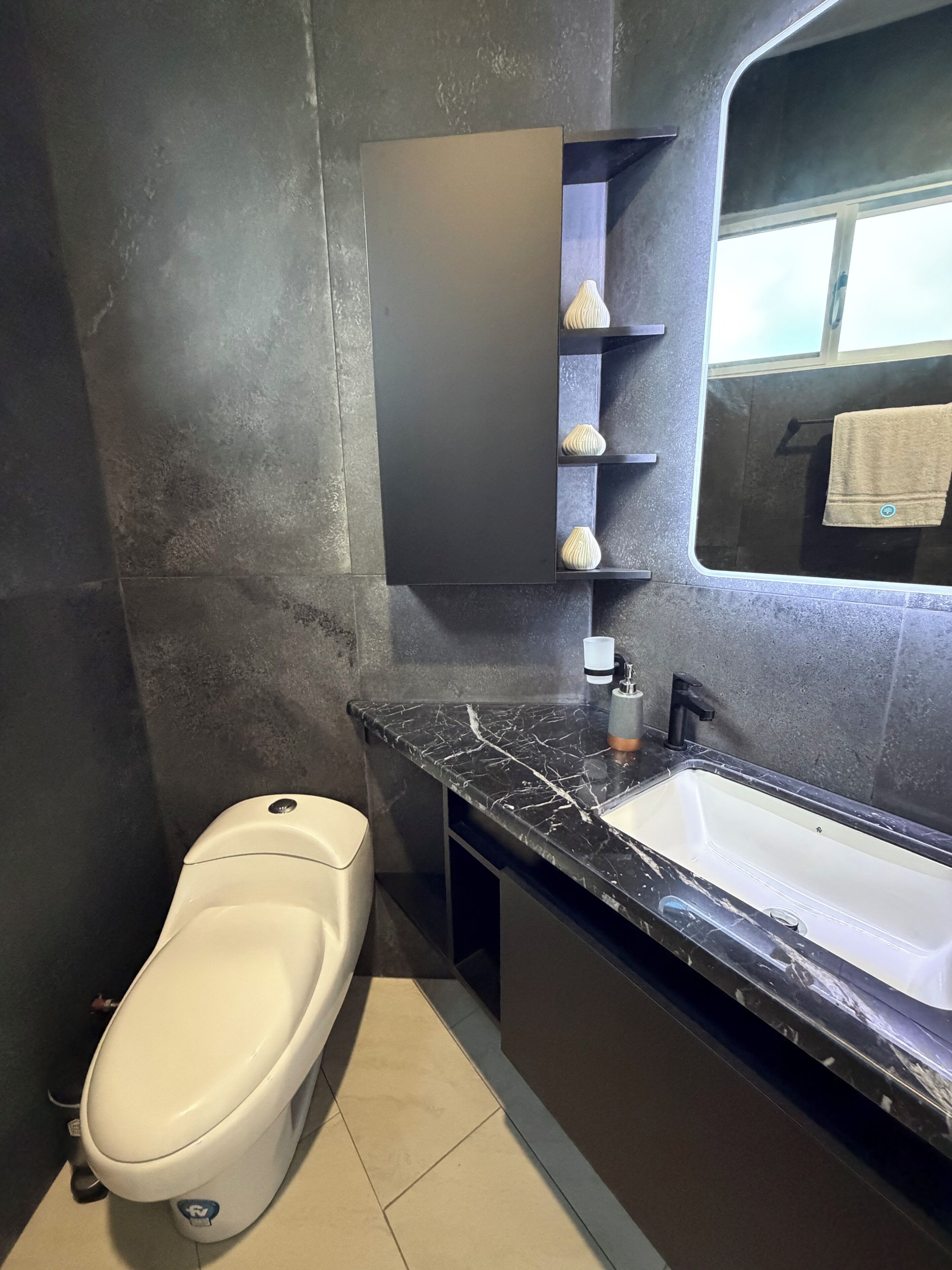 A modern bathroom with a toilet, a sink, and a mirror.