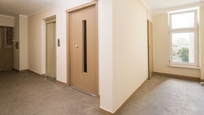 A hallway with a door, a window, and a ceiling light.