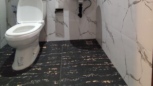 A bathroom with a toilet, sink, and mirror. - Moonrise Rooms (Pecatu)