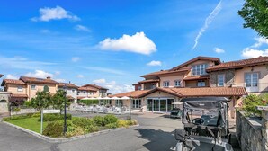A hotel with multiple buildings, a reception area, outdoor seating, and a golf cart.