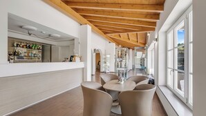 A modern interior with a bar area, seating, and large windows.