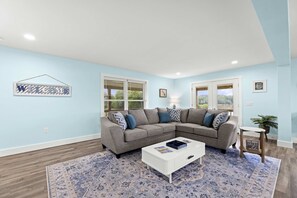 A living room with a sectional sofa, a coffee table, and a patterned rug. - Lakefront Lake Anna | Hot Tub, Beach & Game Room (Orange)