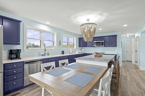 A modern kitchen with a central island, built-in appliances, and a chandelier. - Lakefront Lake Anna | Hot Tub, Beach & Game Room (Orange)