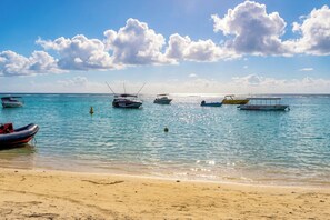 A beach with several boats anchored in calm waters, a sandy shore, and a clear sky with clouds. - Villa Garden House GH06, Pool & Holidays, 2 Min To Beach, Mauricius, Mauritius (Mauricius)