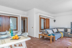 A dining area with a table set for two, a sofa, and a small table with snacks. - Il Faro di Capo Ceraso, Murta Maria, Italy (Murta Maria)