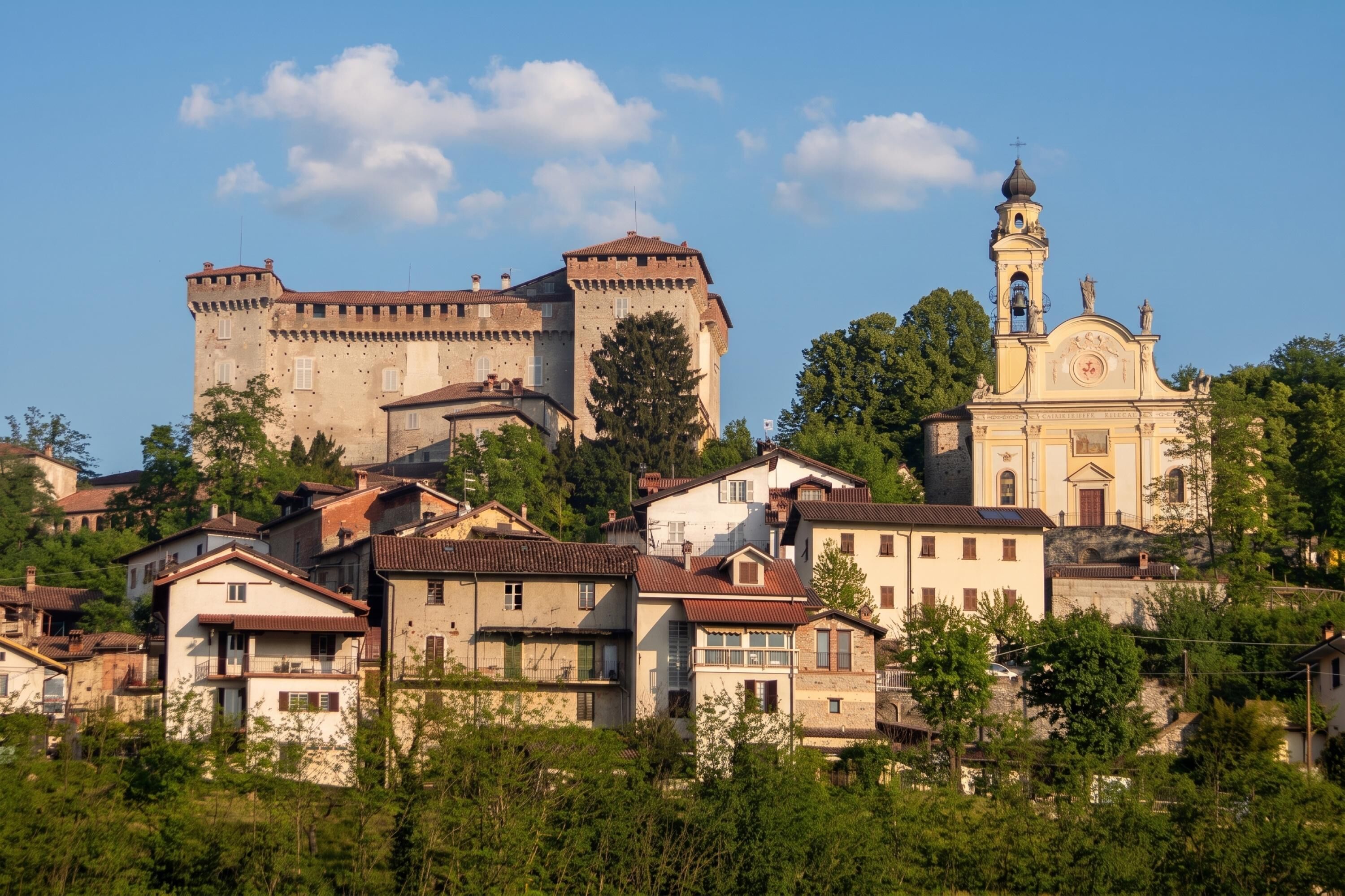 A historic town with a prominent castle and a church with a bell tower.