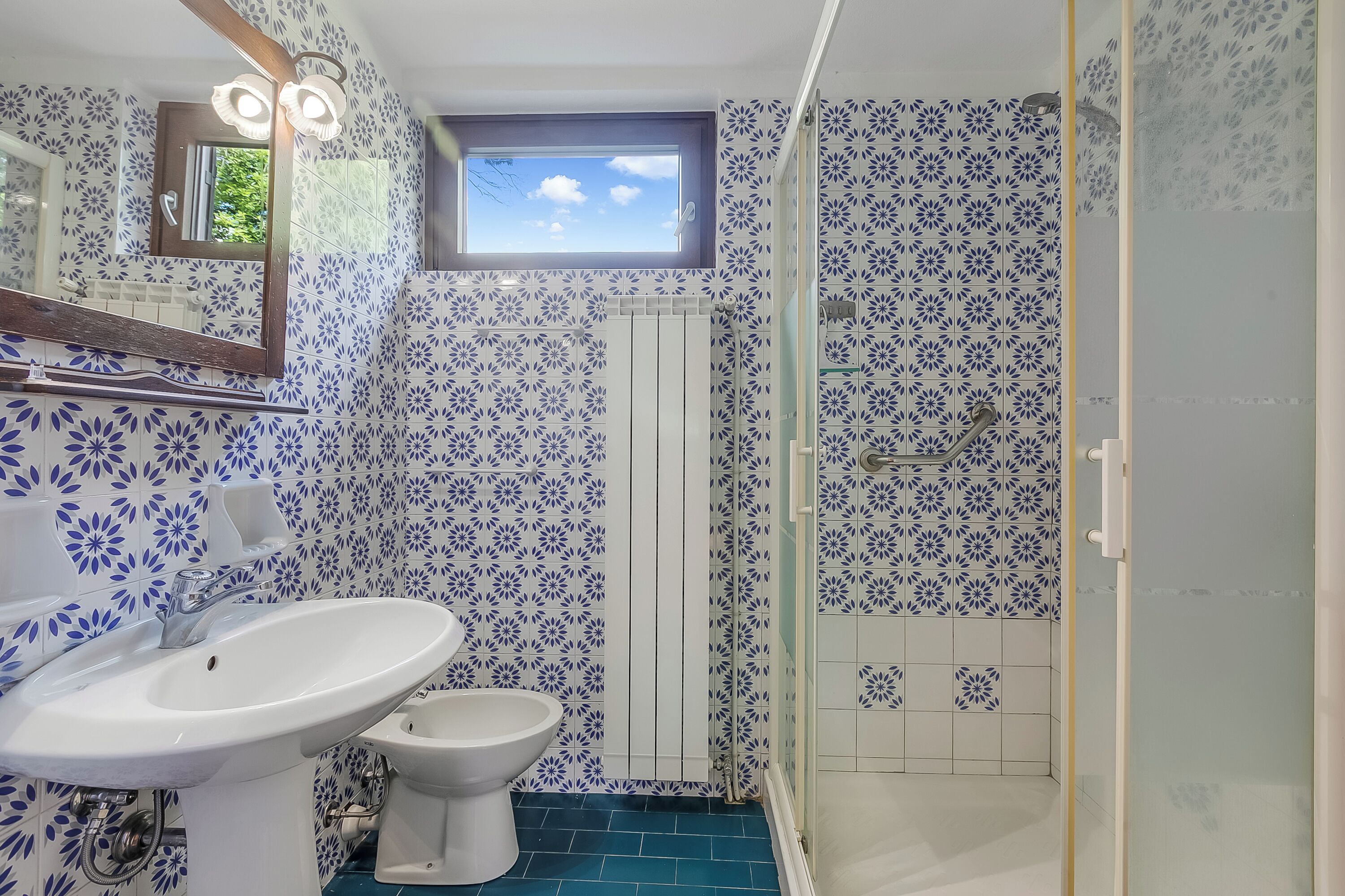 Ein Badezimmer mit weißem Waschbecken, WC und Dusche.