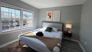 A bedroom with a bed, a window, a bedside table, and a lamp. - Central 1BR Birmingham Suite with Parking Near Legion Field (Birmingham)