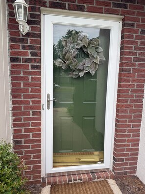 Eine Tür mit Fensterteil und dekorativem Kranz.