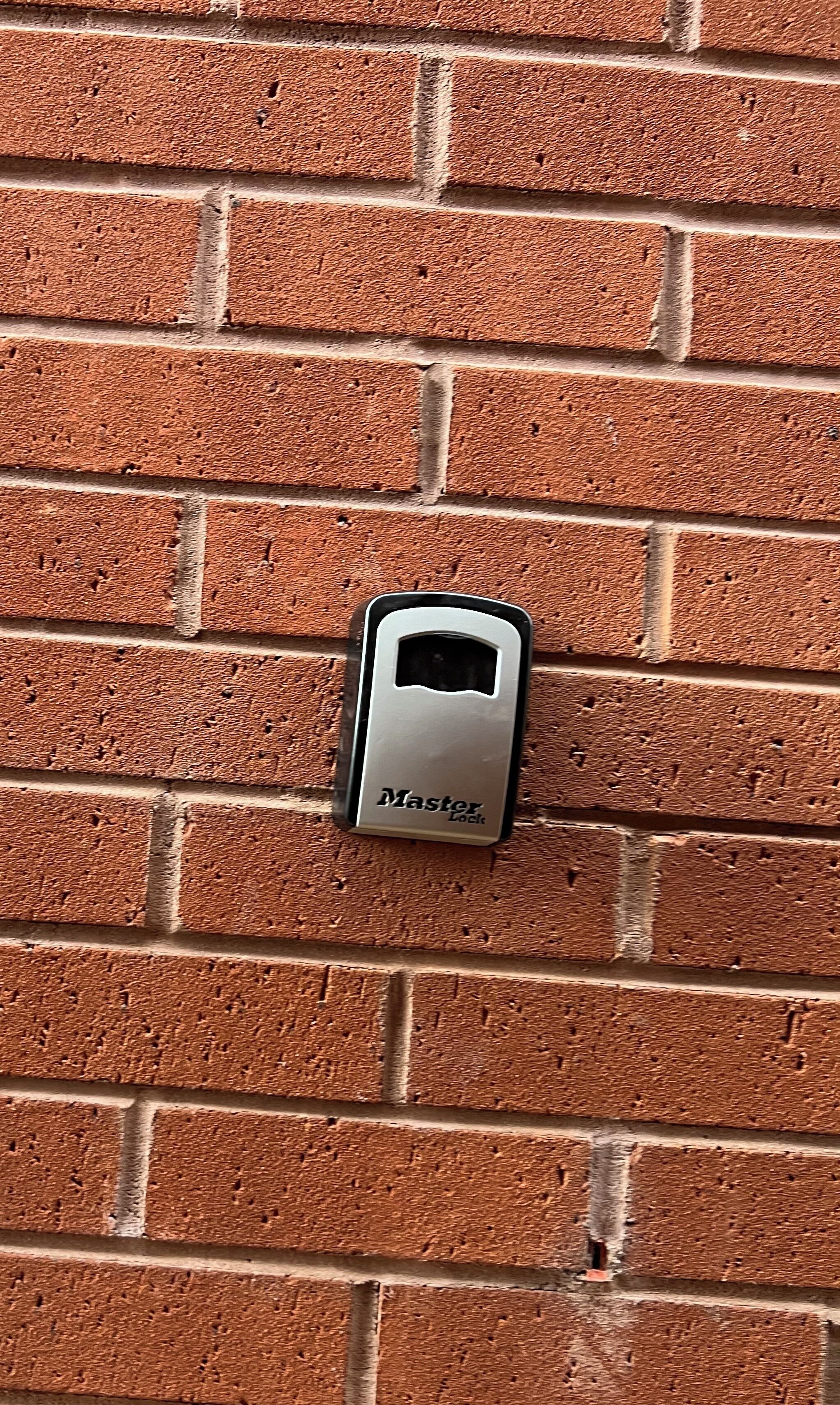 En Master Lock fastgjort på en murstensvæg.
