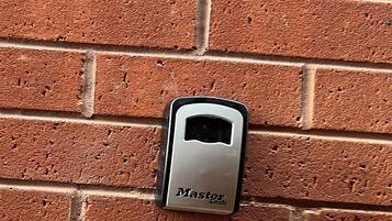 En Master Lock fastgjort på en murstensvæg.