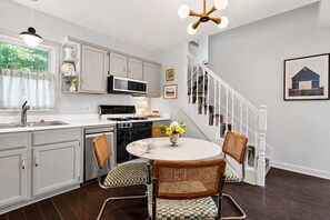 A kitchen with a dining area, a staircase, and a view of the outdoors. - Louisville Retreat | Hot Tub, Ping Pong, 3 Kings (Louisville)