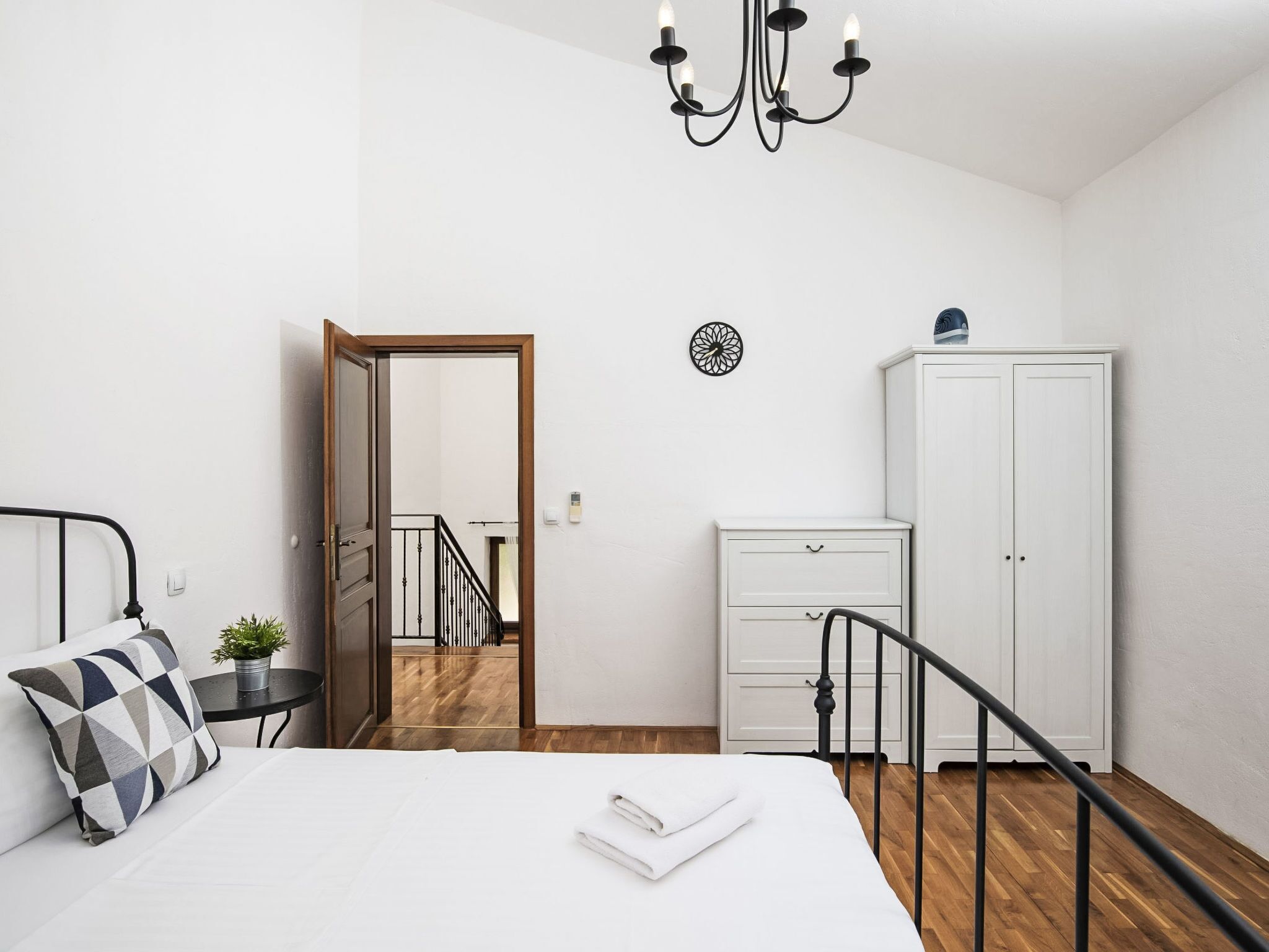 Une chambre à coucher comprenant un lit, une table de chevet, une lampe, une armoire et un miroir.