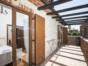 A room with a bed, a wooden door, a drying rack, and a view of the outside. - Vacation home Orlene by Interhome (Pula/Vodnjan)