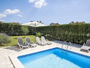 A swimming pool with lounge chairs and a sun umbrella. - Vacation home Orlene by Interhome (Pula/Vodnjan)