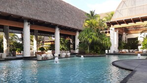 Uma área de piscina com espreguiçadeiras e um elemento central de água.