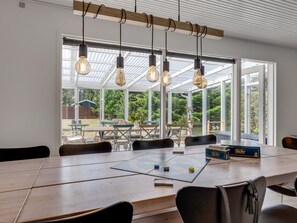 A spacious room with a long table, chairs, and hanging light fixtures. - "Anina" - 300m from the sea by Interhome (Idestrup)