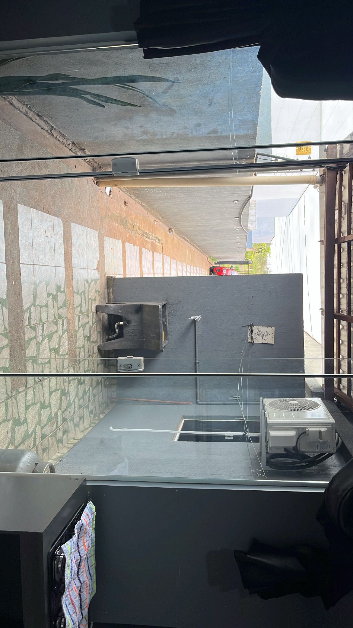 Cozinha com painel de azulejos, pia e ventilador.