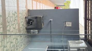 Cozinha com painel de azulejos, pia e ventilador.