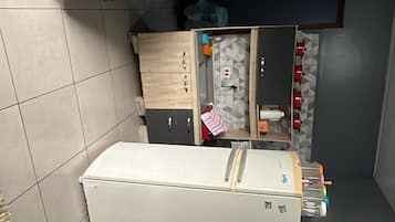 A compact kitchenette with a microwave, a small refrigerator, and a sink.