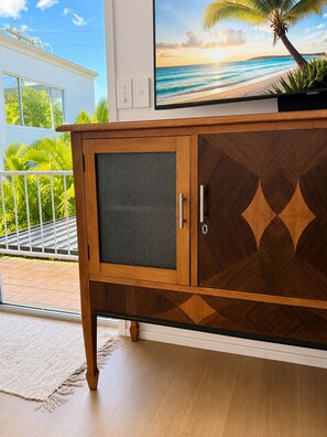 A wooden cabinet with a glass door and a screen door, placed in a room with a view of a balcony. - "Palm Cove" @ Palm Beach Southern GC - Walk To Beach - Pet Friendly (Palm Beach)