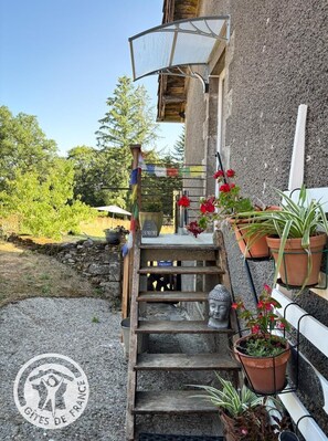 A wooden staircase leading to a building with a sign reading 'GITE DE FRANCE' and a Buddha statue. - La Parenthèse - SOUSCEYRAC IN QUERCY (SOUSCEYRAC EN QUERCY)