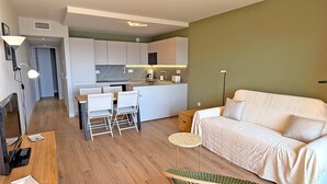 Um espaço compacto com cozinha compacta, área de jantar e sofá.