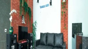 A living room with a sectional sofa, a television, and a fireplace. - Cozzy Villa Dewata (batu)