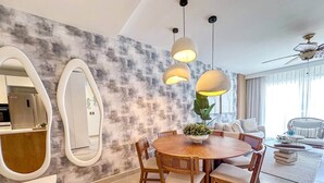 Een moderne eetruimte met een ronde houten tafel, stoelen en hanglampen.