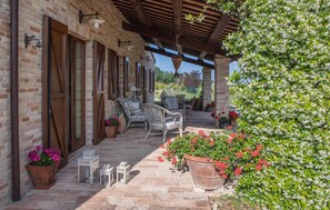 A covered outdoor patio with brick walls, wooden beams, and outdoor furniture. - 6 bedroom pet friendly home in Potenza Picena (Potenza Picena)