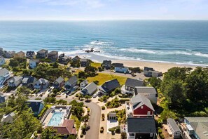 A coastal residential area with houses, a beach, and a swimming pool. - Ocean Views, Hot Tub, Fireplaces & Luxury Finishes, Chef's Kitchen, Community Pool, EV Charger, BBQ (Lincoln City)
