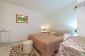 Ein Schlafzimmer mit Bett, Nachttisch, Lampe und einem Bild an der Wand.