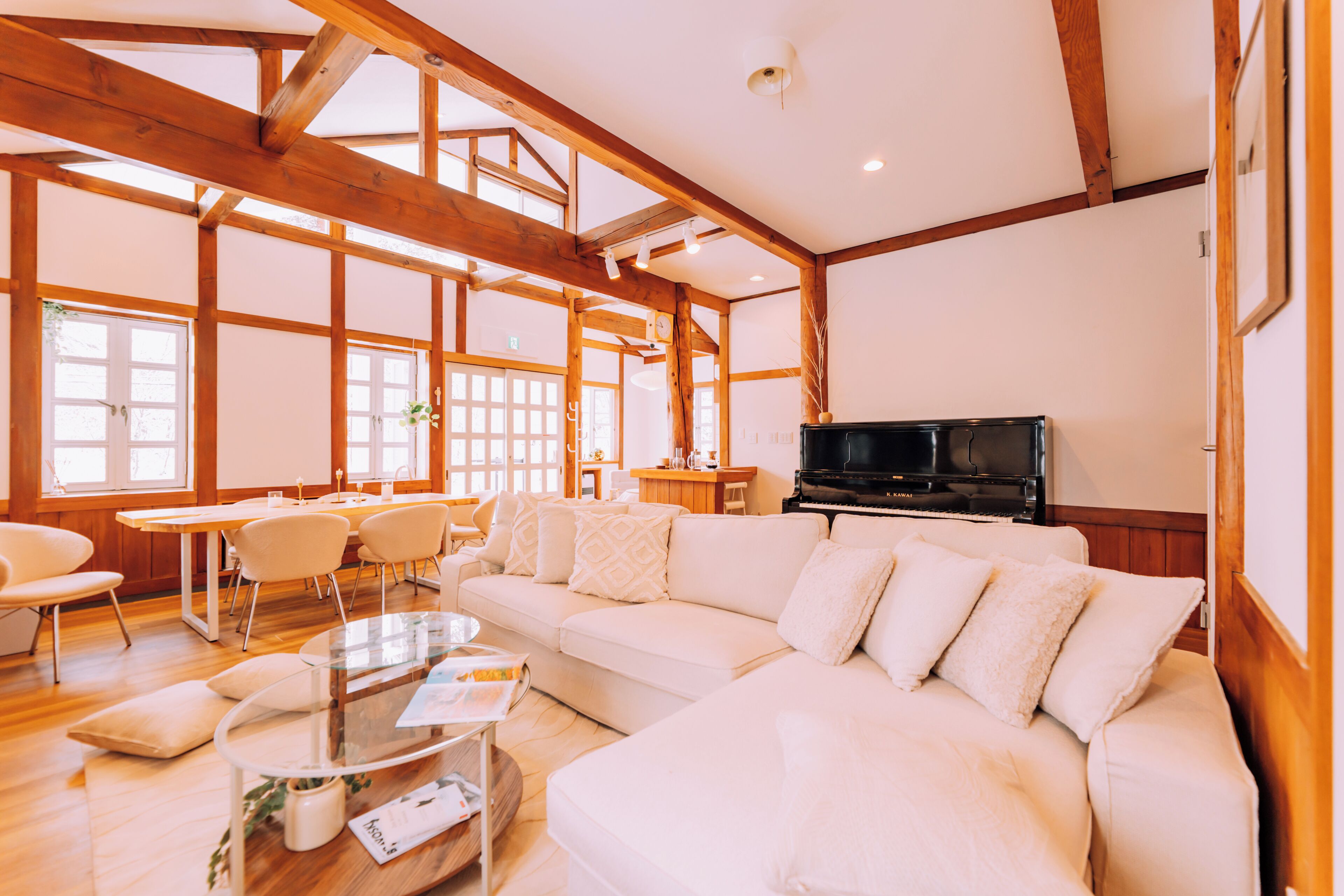 A spacious living room with a large sectional sofa, a glass coffee table, and a television.