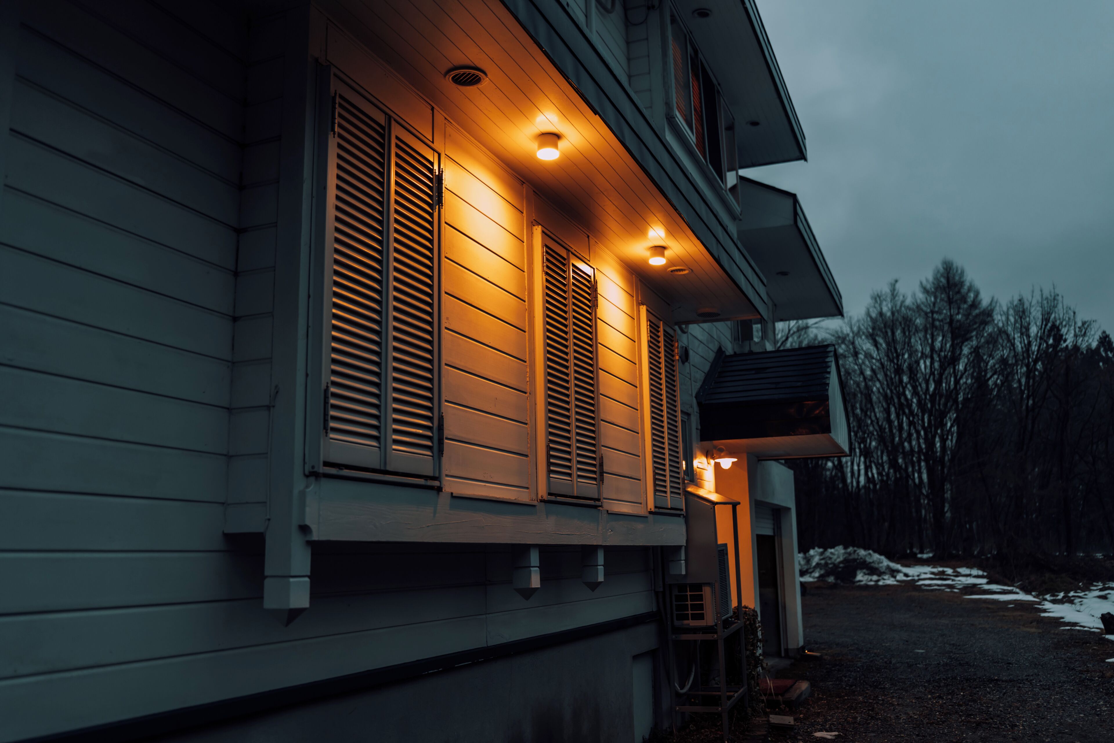 Et hus med veranda, overdækket indgang og synlig garageport.