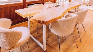 A conference room with a long table, chairs, and a wooden ceiling structure. - Stylish Hakuba Whitegrove Sauna Chalet (Hakuba)