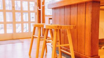 A wooden bar area with two stools and a wooden counter.