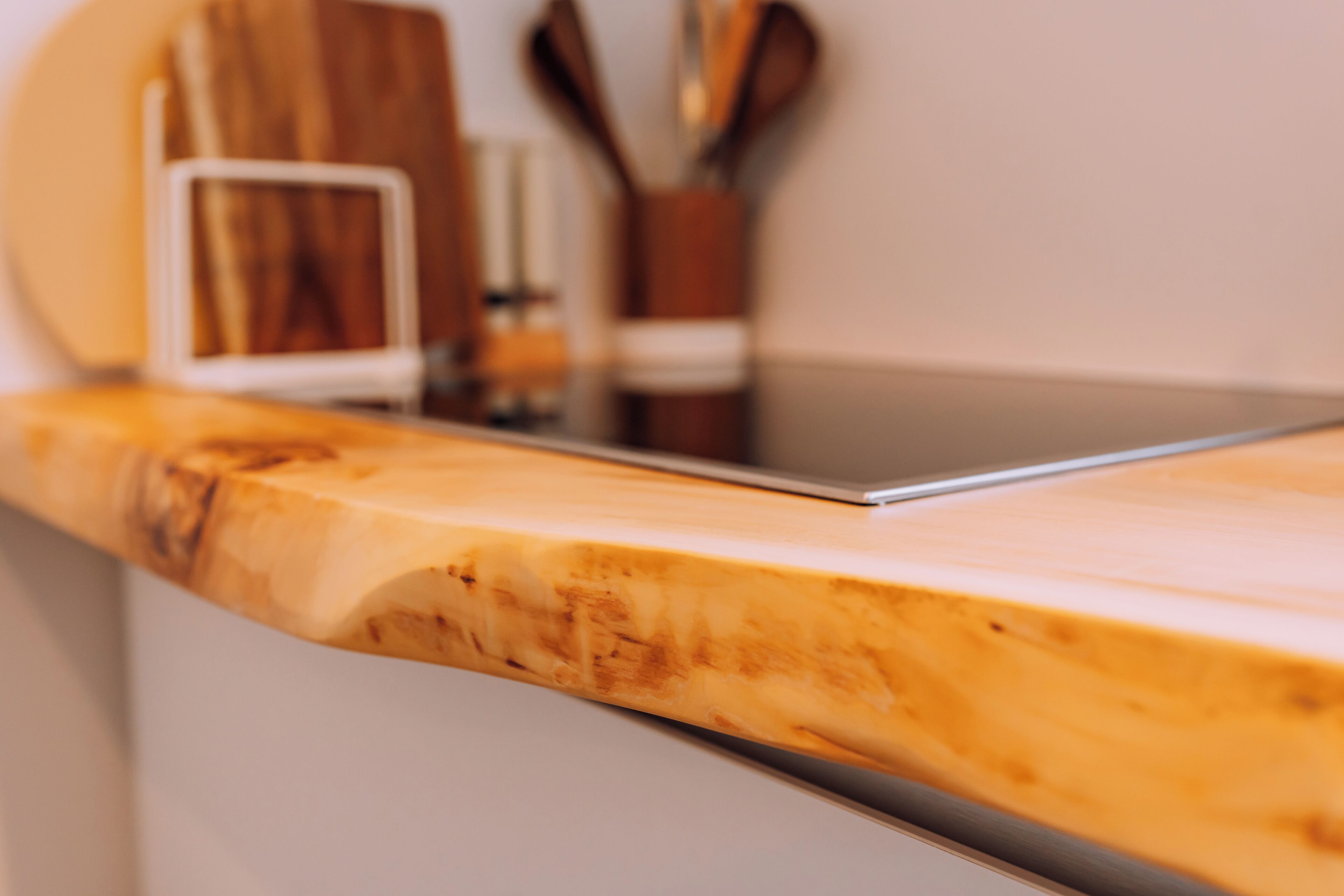 A kitchen counter with a wooden surface and a stainless steel sink.