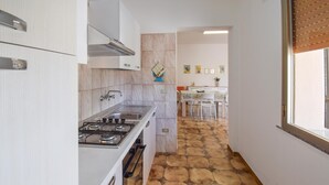 A narrow kitchen with a gas stove, white cabinets, and a tiled floor. - Amazing home in Ispica with WiFi (Ispica)
