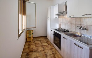 A compact kitchen with a gas stove, sink, and white cabinets. - Amazing home in Ispica with WiFi (Ispica)