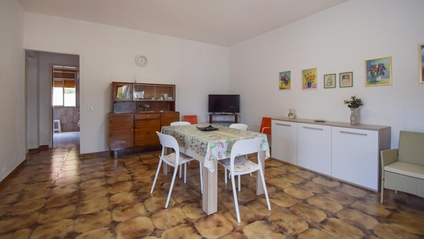 A dining area with a table and chairs, a television, and a cabinet with decorative items. - Amazing home in Ispica with WiFi (Ispica)