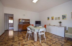 A dining area with a table and chairs, a television, and a cabinet with decorative items. - Amazing home in Ispica with WiFi (Ispica)