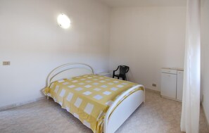 A bedroom with a bed, a chair, a small table, and a wardrobe. - Amazing home in Ispica with WiFi (Ispica)
