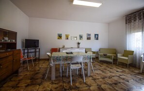 A living room with a dining table, chairs, a television, and artwork on the wall. - Amazing home in Ispica with WiFi (Ispica)